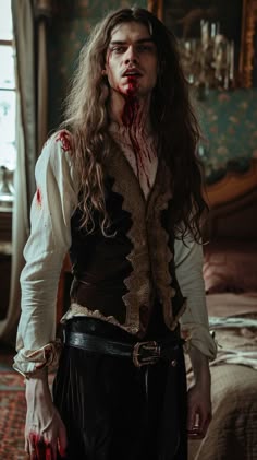 a man with long hair and blood on his face standing next to a bed in a room