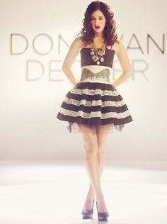 a woman standing in front of a white and black dress with words above her head