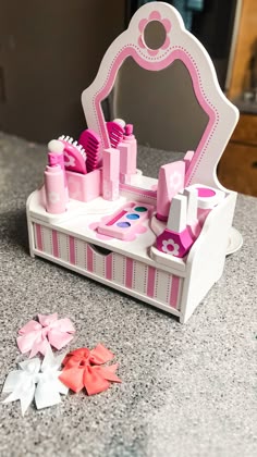there is a toy vanity with pink and white accessories