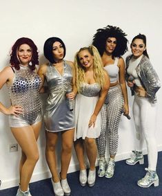four women dressed in silver posing for the camera
