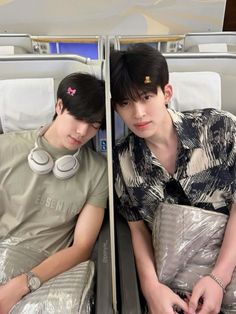two young men sitting next to each other on an airplane