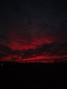 the sky is dark and red with clouds