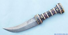 a knife that has been decorated with gold and silver strips on it's blade