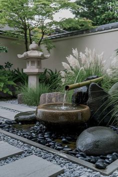 a water fountain surrounded by rocks and plants