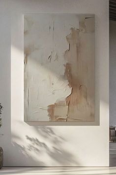 a painting hanging on the wall next to a potted plant