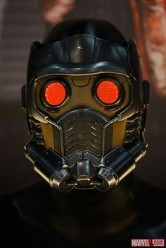 a close up of a helmet with red eyes
