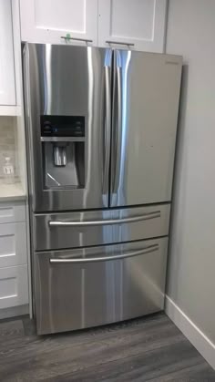 a stainless steel refrigerator in a white kitchen