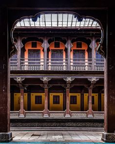 an old building with many windows and balconies on the outside, in front of a blue pool