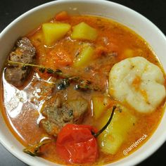 a white bowl filled with meat and vegetables