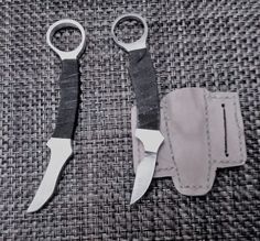 two pairs of scissors sitting next to each other on a cloth covered surface with stitching