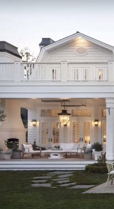 a large white house sitting on top of a lush green field