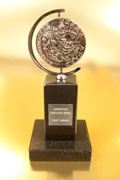 an award is displayed on top of a black stand with a silver medallion in the center
