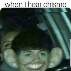 a man sitting in the back seat of a car next to another person with their hands on his head