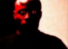a blurry image of a man with red eyes and an evil look on his face