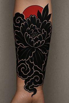 a woman's arm with black and red flowers on it