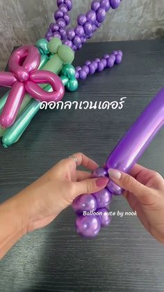a person is holding an inflatable purple balloon with a bow on the top