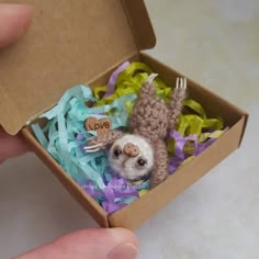 a small stuffed animal in a box filled with streamers