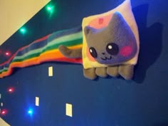 a stuffed animal is hanging on the wall in front of a rainbow colored light fixture