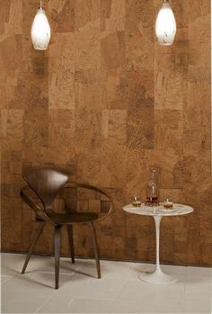two chairs and a table in front of a wall with wood paneling on it