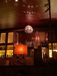 a disco ball hanging from the ceiling above a bar