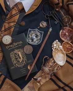 a harry potter book and some other items on a blanket with the hogwarts crest