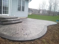 a concrete patio with steps leading up to the house
