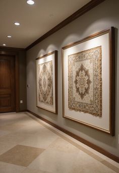 two framed art work hanging on the wall in a room with beige carpet and white walls