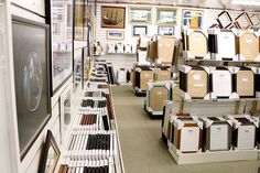 there are many items on the shelves in this store that is full of boxes and frames