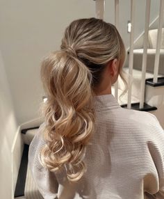 This soft, layered ponytail is as cute as it is classy. With voluminous curls falling gently over the shoulders, it gives major bridal or bridesmaid energy. The blend of light blonde tones makes the movement of the curls even more eye-catching.  Ideal for wedding weekends, date nights, or parties. To maintain the bounce, use hot rollers and finish with a soft-hold setting spray. It’s particularly flattering for women with finer hair, offering both volume and elegance. Simple Curled Ponytail, Curled Ponytail Wedding, Curled Ponytail Wedding Hair, Low Curled Ponytail Wedding, Bridesmaid Curled Ponytail, Hair Up Curled Ponytail, Formal Curled Ponytail, Prom Pony, Blonde Wedding Ponytail