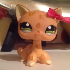 a close up of a toy cat with a bow on it's head and eyes