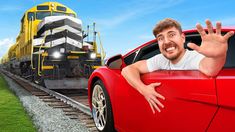 a man leaning out the side of a red car next to a train on tracks