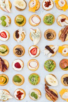 many different types of pastries are arranged on a white surface with various toppings