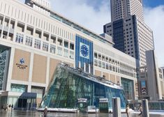 people are walking in front of a building with a clock on it