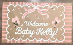 a welcome baby sign with pink flowers on it