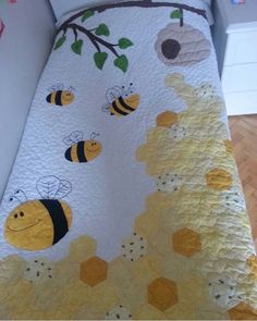 a bed with bees and honeycombs on the cover is next to a wall