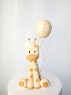 a cake with a giraffe on it and a balloon attached to the top