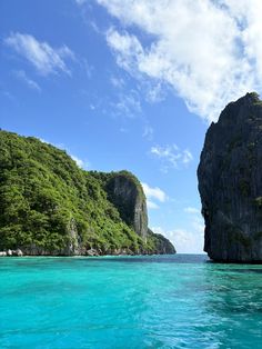 the water is crystal blue and there are two large rocks in the middle of the ocean