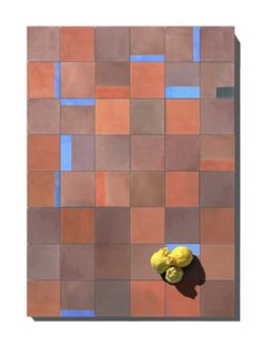 two lemons sitting on top of a table in front of a wall made of tiles