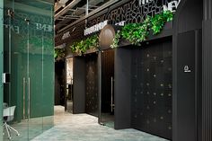 the interior of an office building with plants growing on the wall and doors to other areas