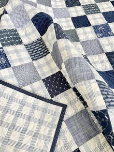 a blue and white quilt is laying on top of a tablecloth that has been folded over