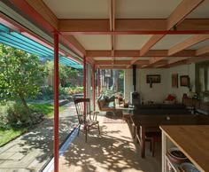the inside of a house with wooden flooring and glass doors leading to an outside patio