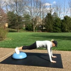 a woman doing push ups on a blue exercise ball