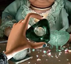 a woman is holding a green vase in front of an elephant figurine on a table