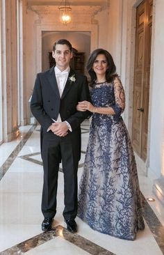 a man in a tuxedo and a woman in a blue dress standing next to each other