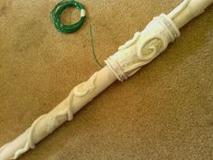 a white pipe laying on the floor next to a green cord