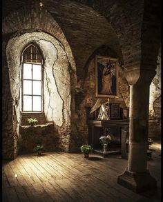 an old room with stone walls and wooden flooring is lit by sunlight coming through the window