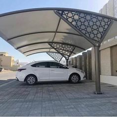 a white car is parked under an awning