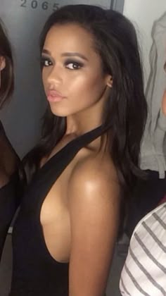 two beautiful women standing next to each other in front of a man and another woman