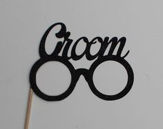 a black cake topper with the word groom on it and two glasses in front