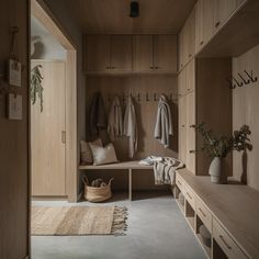 a wooden bench sitting next to a closet filled with coats